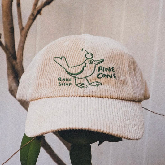 Close-up of a custom cap featuring the Mello Review design by Pinlord.com, showcasing detailed artwork on the fabric.