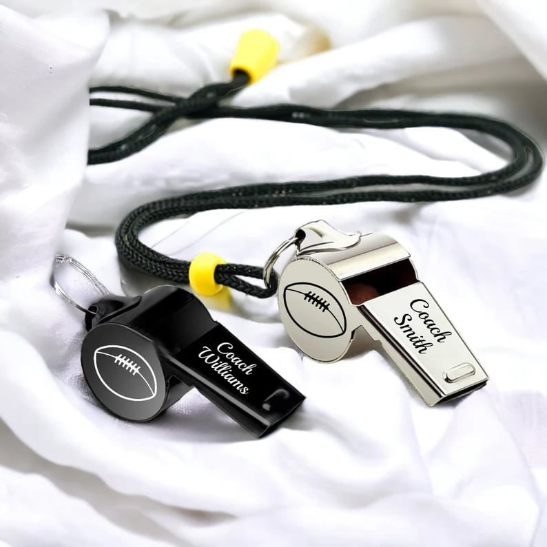 Custom Pinlord.com whistle with engraved design, made of metal, featuring a sleek, polished finish and a lanyard attachment.