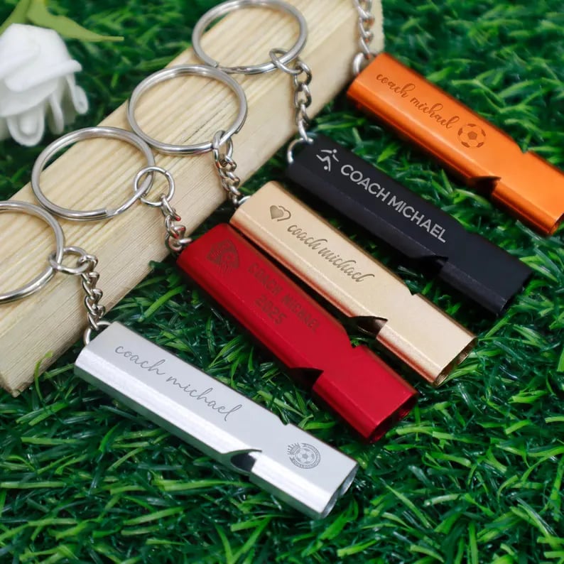 Custom Pinlord.com whistle with engraved design, made of metal, featuring a sleek finish and a functional lanyard hole.