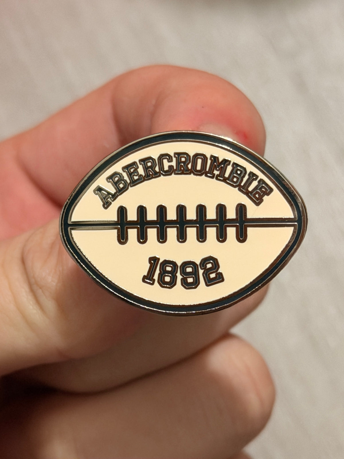 Abercrombie & Fitch Super Bowl after-party custom enamel pins displayed on a project board.
