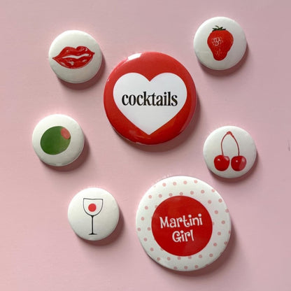Custom button pins featuring unique badge designs by Pinlord.com, shown in a variety of colorful, round badges.