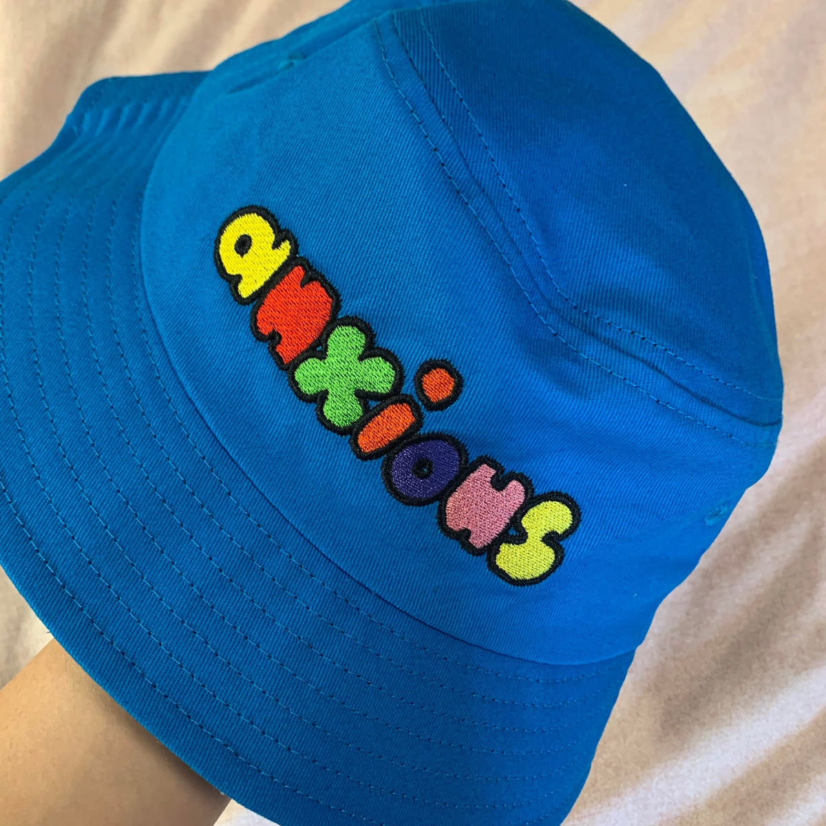 Custom Pinlord.com bucket hat with vibrant design, featuring wide brim and adjustable strap for stylish sun protection.