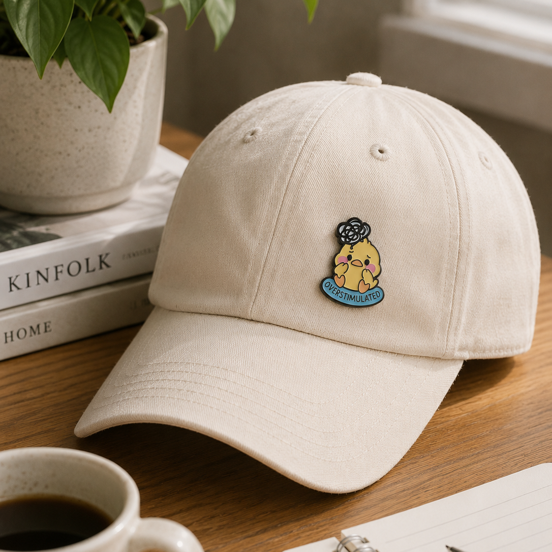 Overstimulated Chick enamel pin featuring a cute, colorful cartoon chick with wide eyes, on a metallic backing.