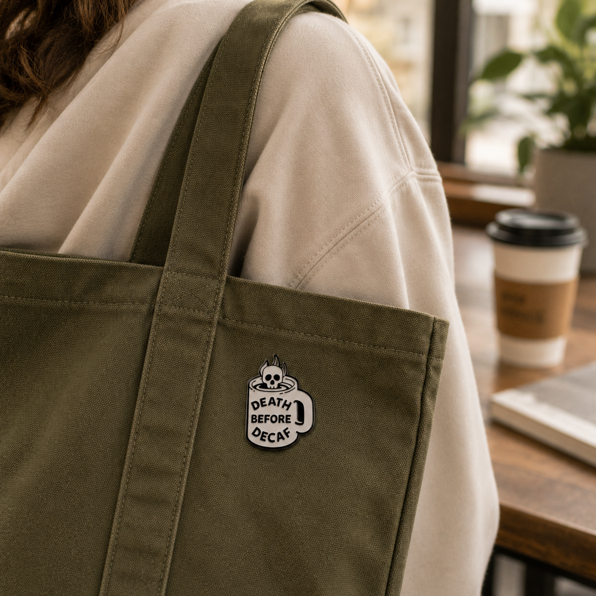 Skull enamel pin featuring "Death Before Decaf" design, black and white detailed metal pin, perfect for accessories or jackets.