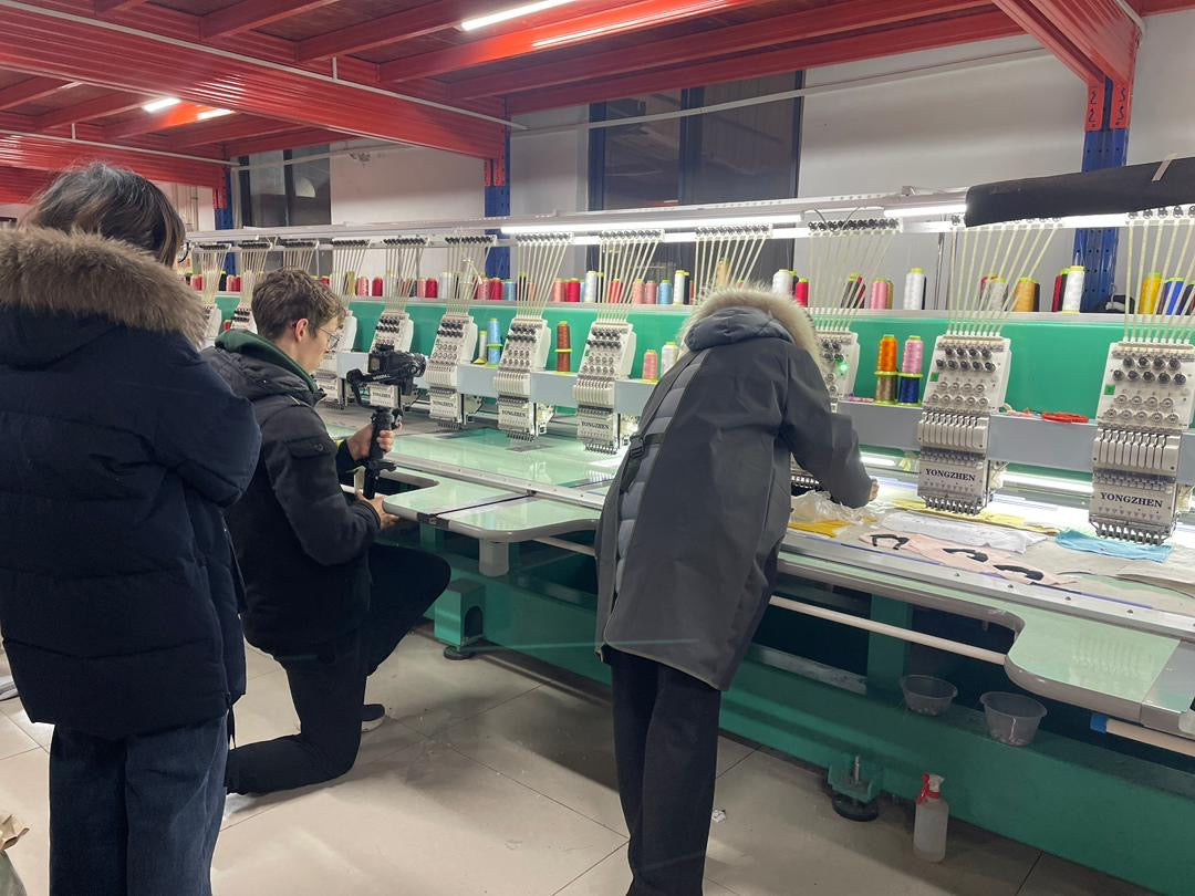 Private factory tour at Pinlord.com showing factory interior with machinery and guided tour setup