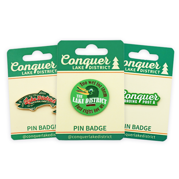 Colorful soft enamel badge featuring a lake district conquer design, with pin badge backing and vibrant enamel colors.