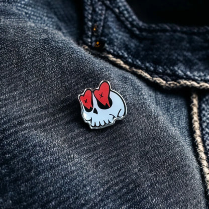 Heart eyes skull enamel pin by Pinlord.com, featuring a detailed skull design with expressive heart-shaped eyes.