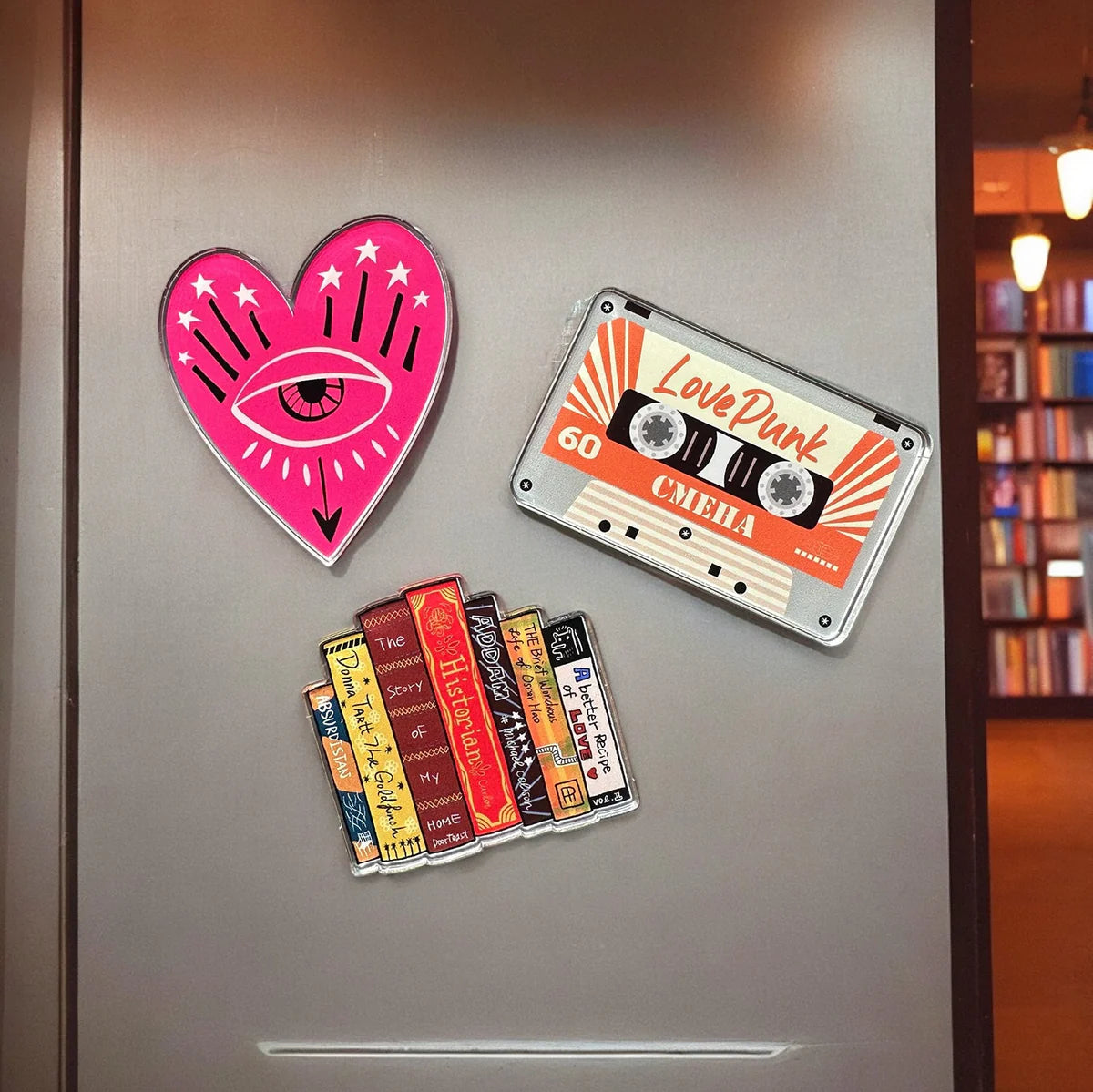 Clear acrylic magnets featuring Zap! Creatives Review branding by Pinlord.com, with vibrant printed designs on each magnet.