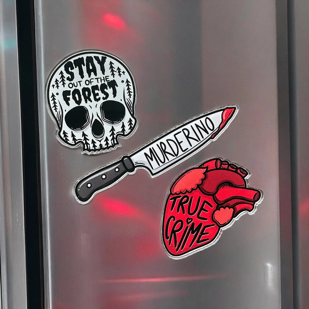 Clear acrylic magnets featuring Zap! Creatives Review design by Pinlord.com, with vibrant graphics on a transparent surface.