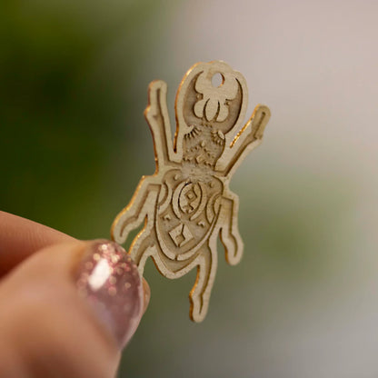 Engraved metal charms featuring Zap! Creatives Review design, by Pinlord.com, displayed on a white background.