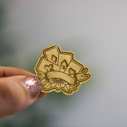 Engraved metal charms featuring Zap! Creatives Review design by Pinlord.com on a black background.