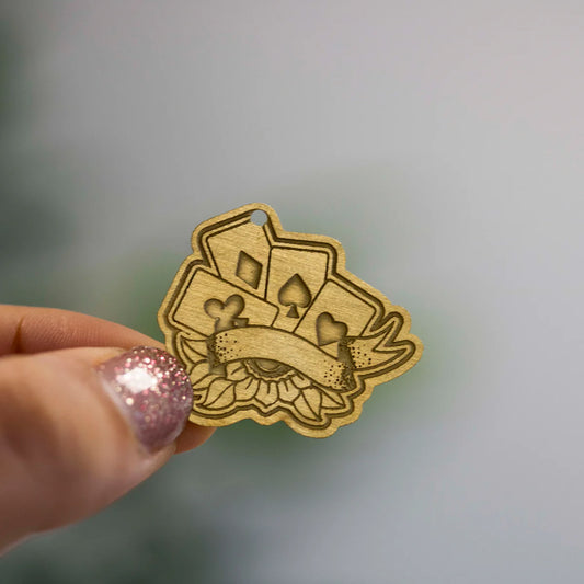 Engraved metal charms featuring Zap! Creatives Review design by Pinlord.com on a black background.