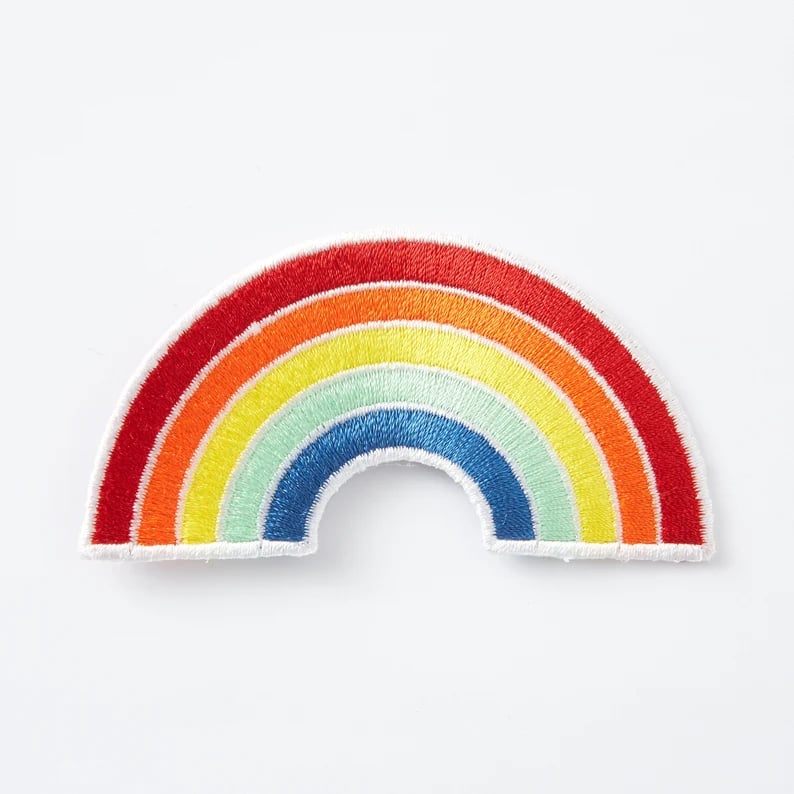 Close-up of custom patches with various embroidered designs on fabric, showcasing unique patches from Pinlord.com