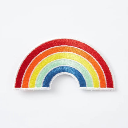 Close-up of custom patches with various embroidered designs on fabric, showcasing unique patches from Pinlord.com