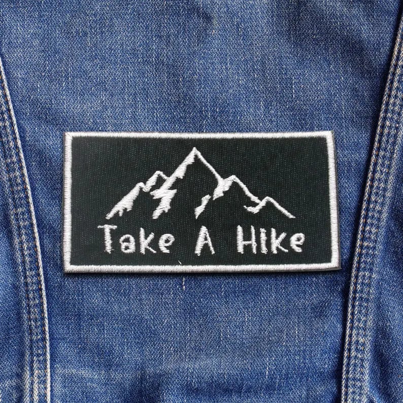 Close-up of colorful custom patches featuring various embroidered designs, ideal for clothing and accessories.