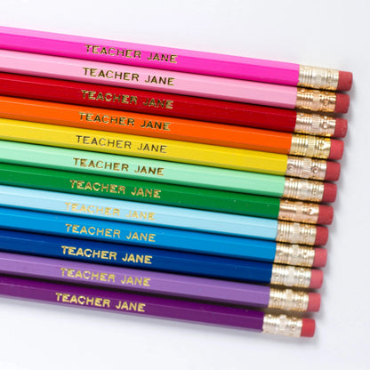 Set of custom pencils with personalized designs from Pinlord.com, featuring colorful pencil tips and engraved branding.