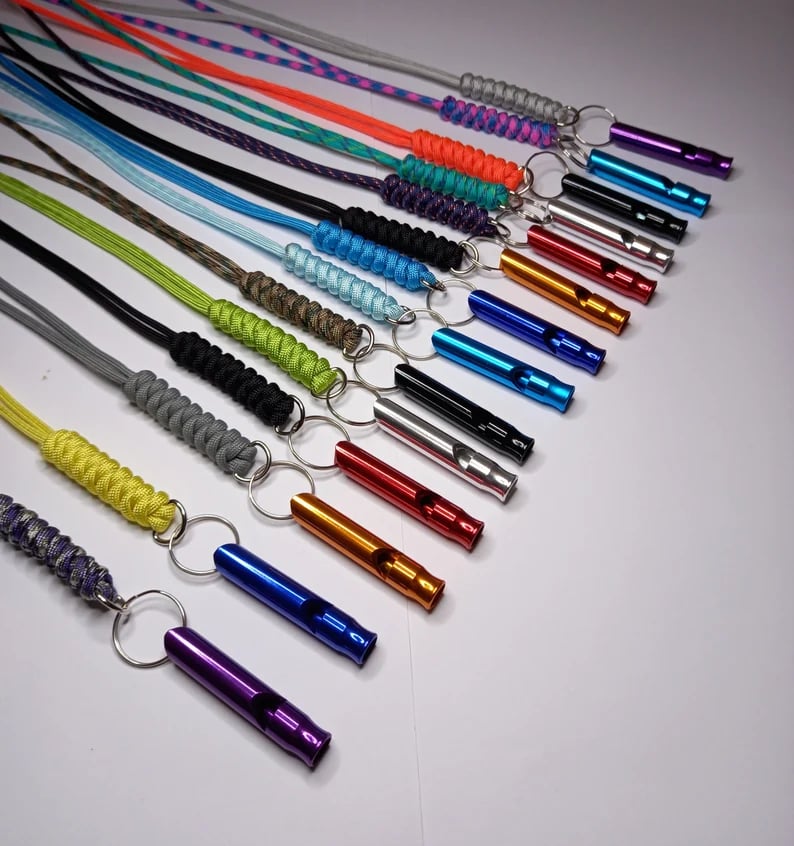 Custom Pinlord.com whistle with engraved design, featuring a sleek metal body and a functional mouthpiece for outdoor use.